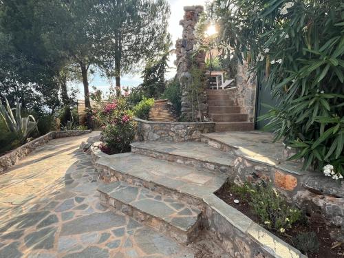 a stone stairway leading to a house with a garden at Pituresque stonehouse with endless view in Prosílion