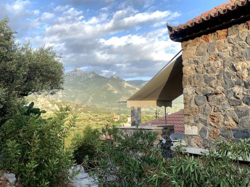 a stone building with a roof with mountains in the background at Pituresque stonehouse with endless view in Prosílion