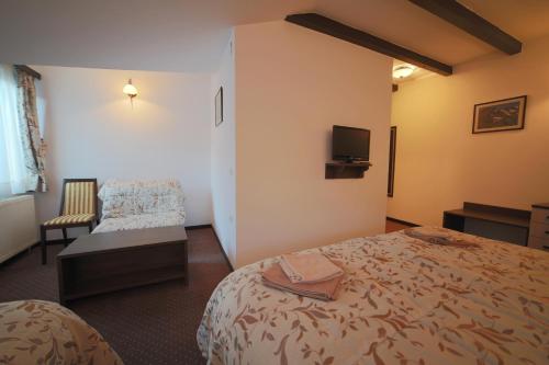 a hotel room with a bed and a chair at Villa od Alula in Vevčani