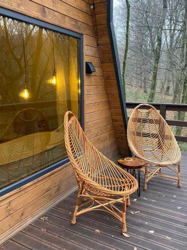 two wicker chairs sitting on the porch of a cabin at Там, де файно in Onokovtsy