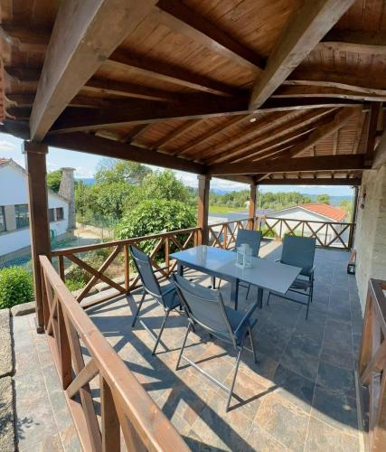 a patio with a table and chairs on a deck at Casa da Montanha in Fataunços