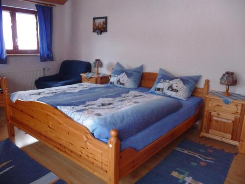 a bedroom with a large wooden bed with blue sheets at Haus Pfaff in Vöhrenbach