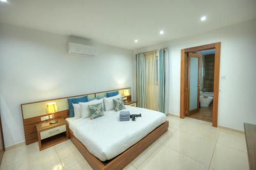 a bedroom with a large bed and a bathroom at Large 3 bedroom with seafront balcony DDIF1-5 in Sliema