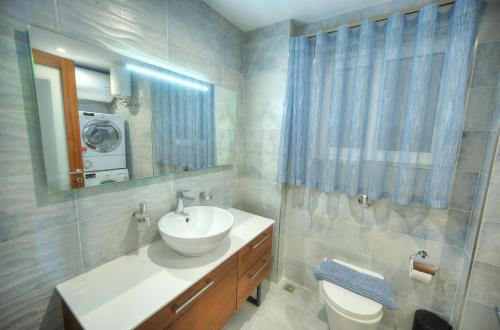 a bathroom with a sink and a toilet and a mirror at Large 3 bedroom with seafront balcony DDIF1-5 in Sliema