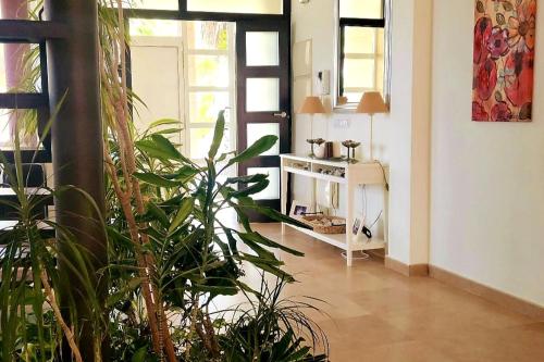 a living room with plants and a table in a room at Casa para disfrutar de ella y su entorno in Águilas