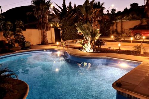 a swimming pool in a yard at night with lights at Casa para disfrutar de ella y su entorno in Águilas