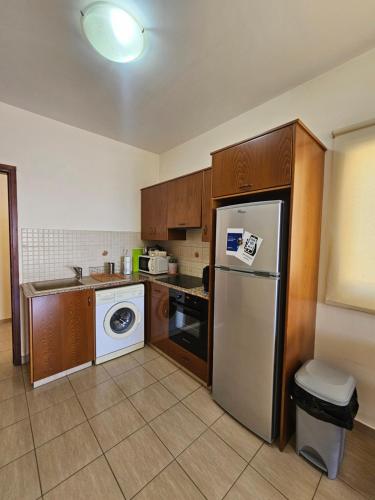 a kitchen with a refrigerator and a washing machine at Lazaros Pissouri Apartments in Pissouri