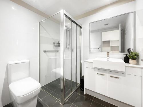 een witte badkamer met een toilet en een wastafel bij Bribie Sunset Vistas in Bongaree