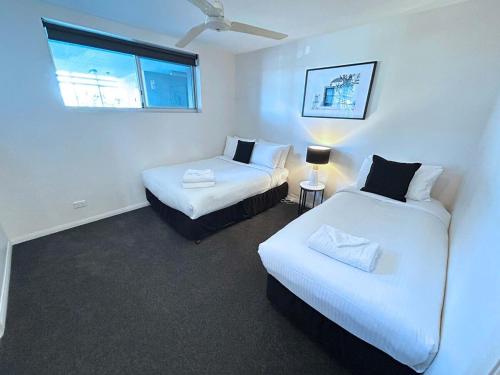 een kamer met twee bedden en een raam bij Bribie Sunset Vistas in Bongaree