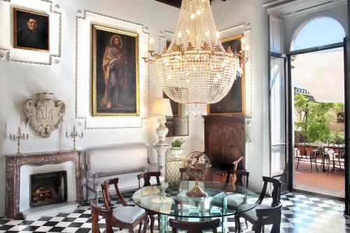 a dining room with a chandelier and a table and chairs at Arnaboldi Palace in Pavia