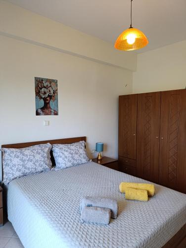 une chambre avec un lit avec deux serviettes dessus dans l'établissement Patoliko, à Nea Moudania