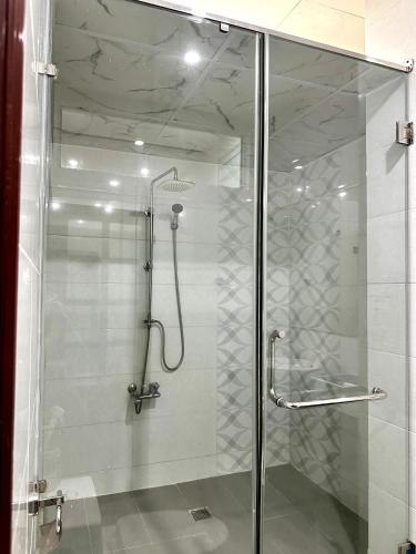 a shower with a glass door in a bathroom at Tinahouse in Danang