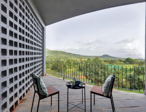 a patio with two chairs and a table with a view at SaffronStays Bonsai in Wādhiware