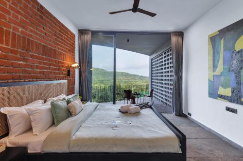 a bedroom with a large bed and a brick wall at SaffronStays Bonsai in Wādhiware