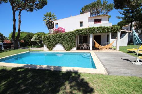 a villa with a swimming pool in front of a house at Villa Dantas by amcf in Vilamoura