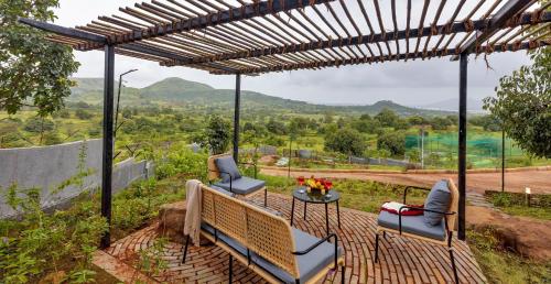 a pergola with two chairs and a table at SaffronStays Bonsai in Wādhiware