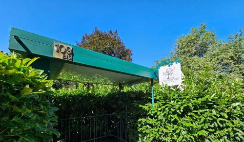 a green building with a sign in front of some bushes at Il Faggio Rosso - Bed & Breakfast in Moncalieri