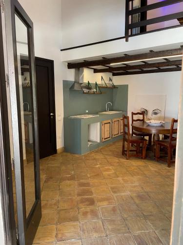 a kitchen and dining room with a table and a sink at Sunset Kite Village in Marsala