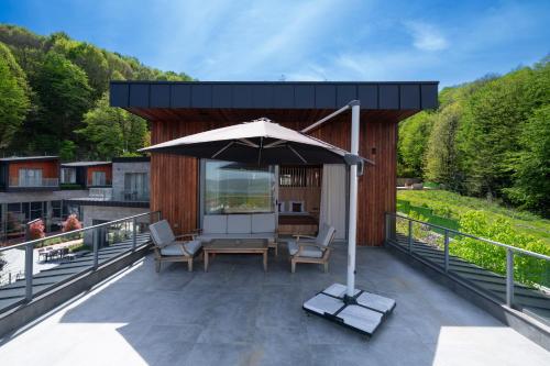 a patio with an umbrella and chairs on a deck at Melekona House in Kartepe