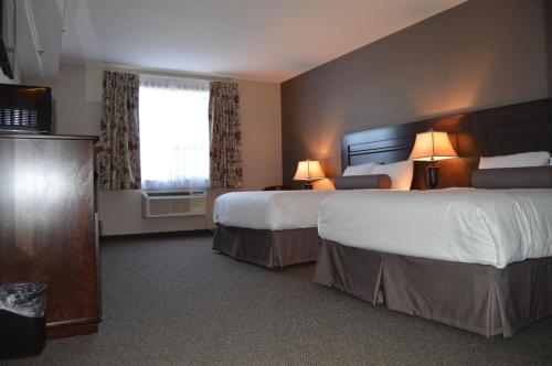 um quarto de hotel com duas camas e uma janela em Cobble Creek Lodge em Maple Creek