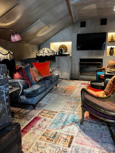 a living room with a couch and a tv at Cobergher Hotel in Kortrijk