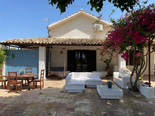 a patio with white furniture in front of a house at Sunset Kite Village in Marsala