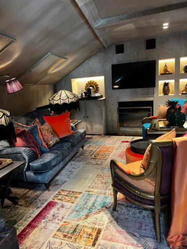 a living room with a couch and a tv at Cobergher Hotel in Kortrijk