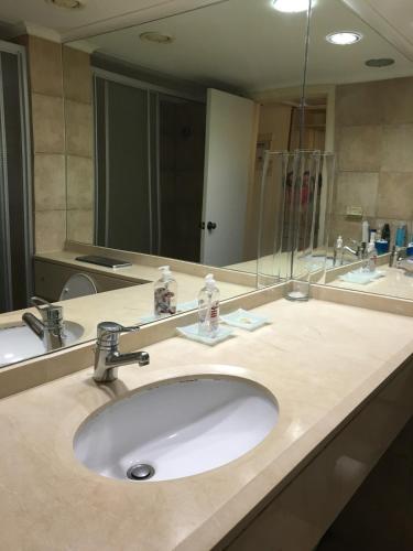 a bathroom with a sink and a large mirror at Sea Vacation in Haifa