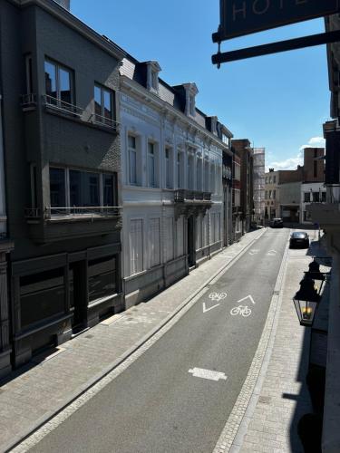 an empty city street with a bike lane on the road at Cobergher Hotel in Kortrijk