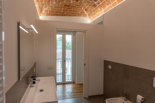 a bathroom with a sink and a mirror and a window at Villa Katalea - piscina privata e barbecue in Asti