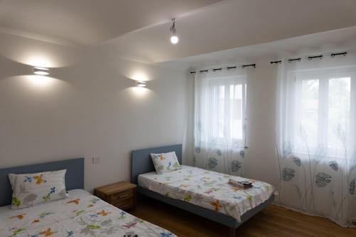 a bedroom with two beds and a window at Villa Katalea - piscina privata e barbecue in Asti