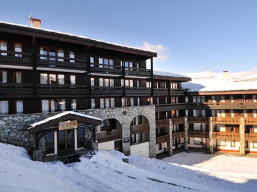 un grand bâtiment avec de la neige devant lui dans l'établissement Studio rénové avec parking gratuit et animaux admis - FR-1-181-2086, à La Plagne Tarentaise