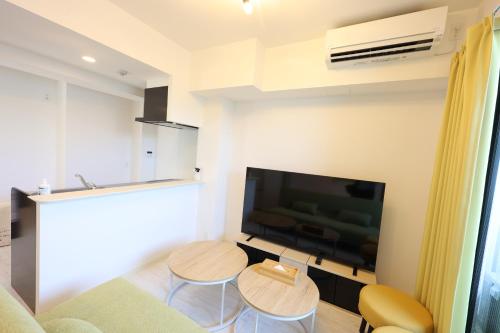 a living room with two tables and a flat screen tv at The Marina Bay in Fukuoka