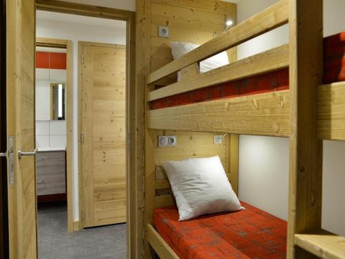Ce lit superposé se trouve dans une chambre en bois dotée d'un oreiller. dans l'établissement Appartement rénové proche des pistes avec espace bien-être - FR-1-181-1908, à La Plagne Tarentaise