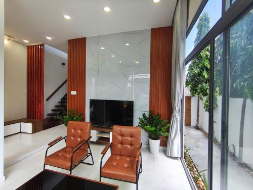 a living room with two chairs and a television at Homestay Lối Nhỏ in Kon Rung (1)
