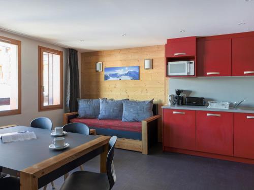 une chambre avec une cuisine et un lit avec des armoires rouges dans l'établissement Appartement rénové avec balcon, bien-être, proche pistes, 6 personnes - FR-1-181-1918, à La Plagne Tarentaise