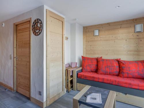 - un canapé rouge dans une chambre dotée d'un mur en bois dans l'établissement Studio rénové ski au pied · Espace bien-être et fitness · Balcon exposé EST - FR-1-181-2026, à La Plagne Tarentaise