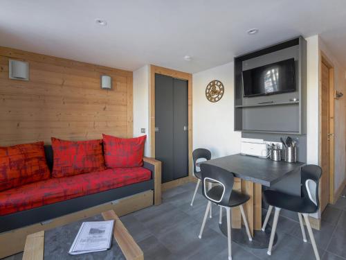 un salon avec un canapé rouge et une table dans l'établissement Studio rénové 3 pers · Proche pistes · Balcon · TV · Animaux admis - FR-1-181-1993, à La Plagne Tarentaise