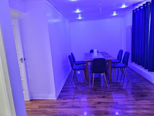 a dining room with a table and blue chairs at Barnsley cozy home 
