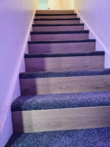 a set of stairs in a house with purple at Barnsley cozy home 
