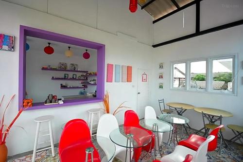 a restaurant with red and white chairs and tables at Na-Rak-O Resort in Chiang Rai