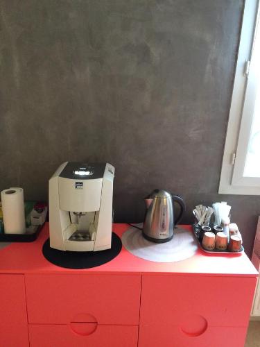 - une cafetière au-dessus d'une commode rouge dans l'établissement L'Eden B&B, à Thiais