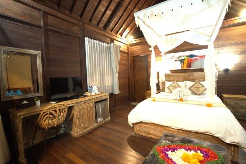 a bedroom with a bed and a television in it at Ocean Terrace Suite And Spa Luxury in Nusa Penida