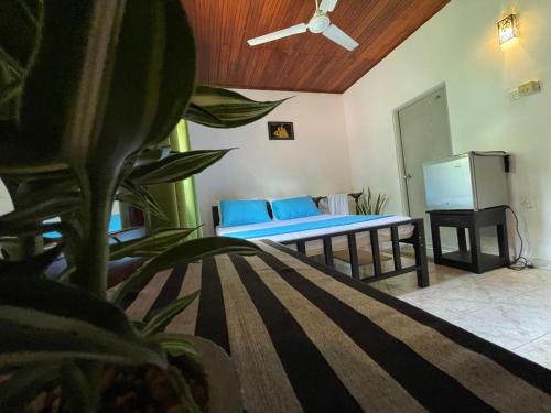 a room with a bed with blue pillows at Sea Waves Home Stay in Talalla