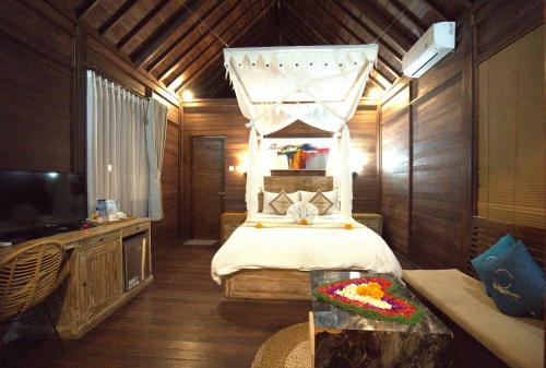 a bedroom with a bed with a canopy at Ocean Terrace Suite And Spa Luxury in Nusa Penida