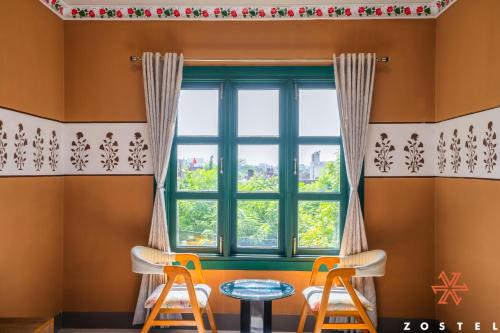 a room with a window and two stools at Zostel Agra in Agra
