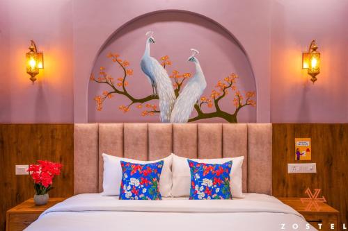 a bedroom with a bed with two peacocks on the wall at Zostel Agra in Agra