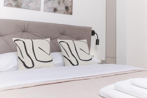 a bedroom with a white bed with white pillows at Autentica Apart in Cetinje