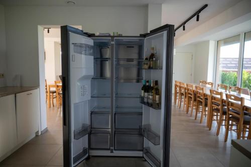 a stainless steel refrigerator with wine bottles in it at Vakantiehuis 't Alkeveld in Zottegem