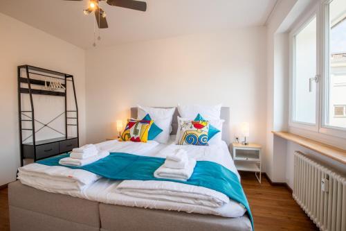 a bedroom with a large bed with towels on it at Special TRIO PICASSO Apartment Basel, Bahnhof Grossbasel 10-STAR in Basel